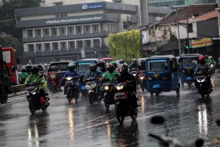 Pengguna kendaraan bermotor menembus hujan di Jalan Menteng Raya, Jakarta, Jumat (22/2/2019). Badan Meteorologi, Klimatologi, dan Geofisika ( BMKG) memprediksi hujan akan mengguyur wilayah Jabodetabek pada Jumat (22/2/2019) siang.