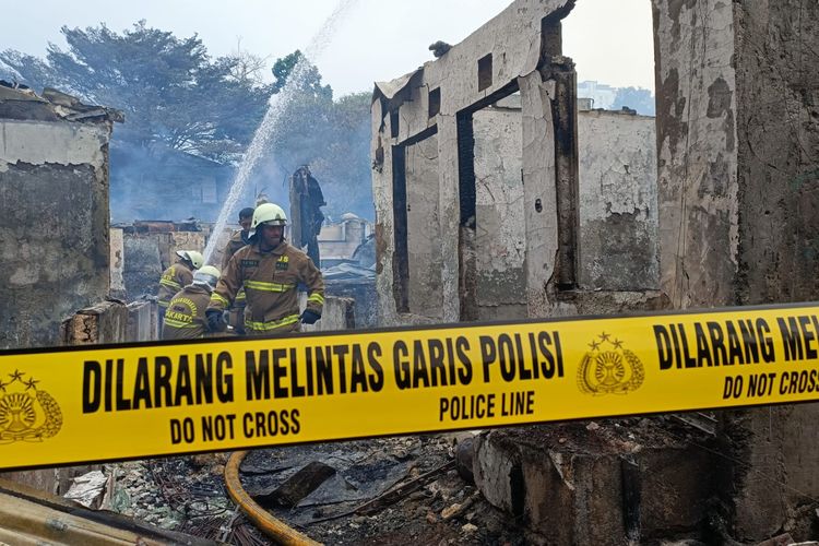 Garis polisi yang sudah dipasang di lokasi kebakaran yang terjadi di Jalan Simprug Golf, Kebayoran Lama, Jakarta Selatan, Minggu (21/8/2022). Selain pemasangan garis polisi, sejumlah petugas pemadam juga terlihat masih memadamkan kepulan asap kecil yang masih terlihat di rumah-rumah warga.