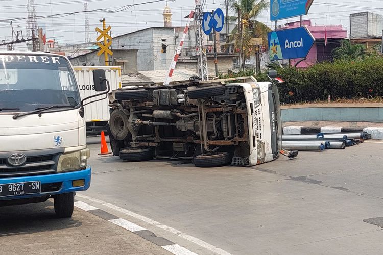Sebuah truk bermuatan tralis dan pipa besi terguling di Jalan RE Martadinata, Pademangan, Jakarta Utara pada Jumat (1/9/2023). 