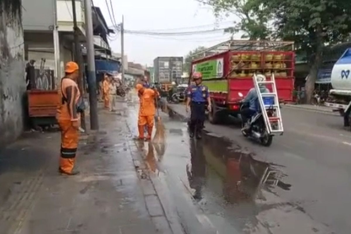 Petugas gabungan di bawah koordinasi Suku Dinas Penanggulangan Kebakaran dan Penyelamatan (Gulkarmat) Jakarta Utara, menyemprot jalan di depan Pelabuhan Sunda Kelapa guna mengantisipasi kecelakaan akibat jalanan berpasir. 