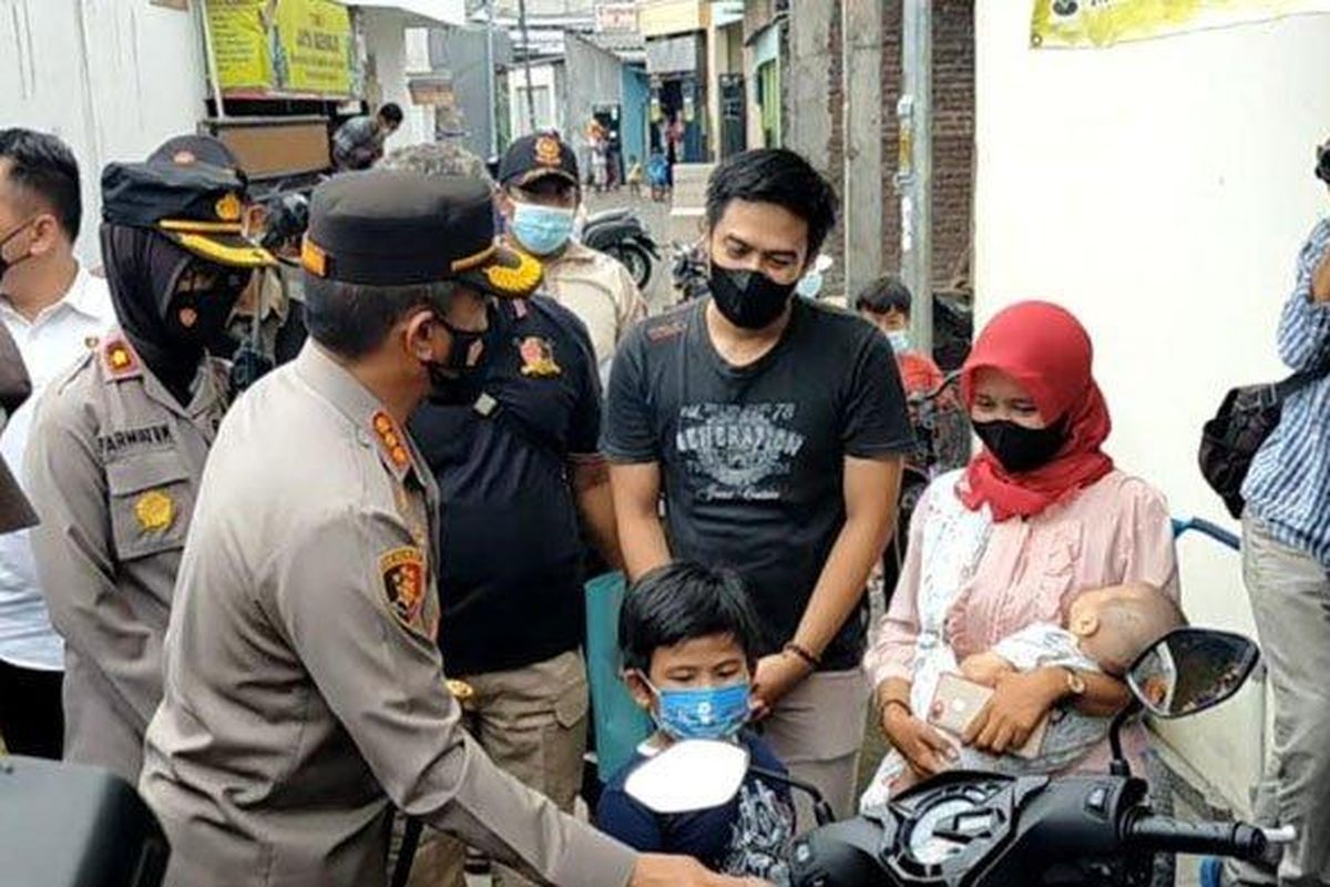 Kapolrestabes Surabaya saat berikan bantuan kepada korban pencurian motor dari Presiden Jokowi 


