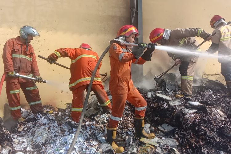 Petugas Damkar Kabupaten Semarang menyemprotkan air untuk memadamkan api yang membakar limbah kertas
