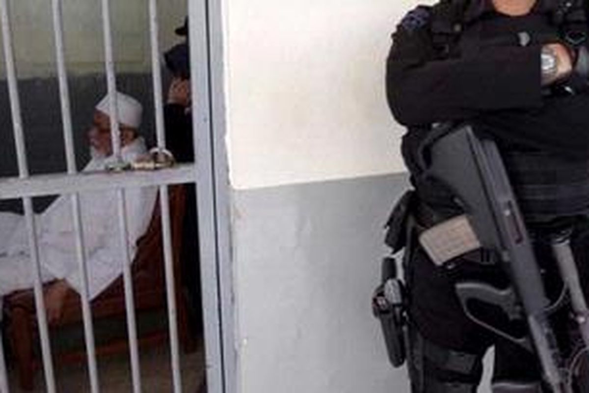 Terdakwa yang diduga terlibat pelatihan teroris di Aceh dan perampokan bank di Medan, Abu Bakar Baasyir menyaksikan keterangan saksi dari layar televisi di ruang tahanan Pengadilan Negeri Jakarta Selatan, Kamis (17/3/2011). Terdakwa beserta tim pengacaranya tetap pada keputusan awal, tidak akan mengikuti sidang saat saksi-saksi memberi keterangan melalui telekonferensi. Sikap itu akan terus diambil hingga ada keputusan dari Komisi Yudisial.