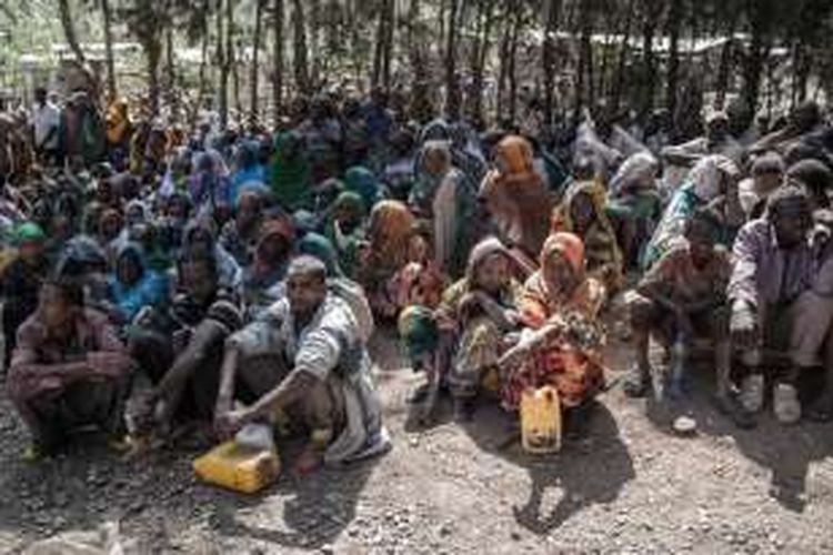 Anggota masyarakat Chelko, Ethiopia, menunggu untuk menerima jatah persediaan makanan, seperti gandum, minyak, dan kacang polong.  Kekeringan telah menyebabkan mereka kekurangan pangan, dan terpaksa harus dijatah secara bergilir untuk mendapat bantuan.
