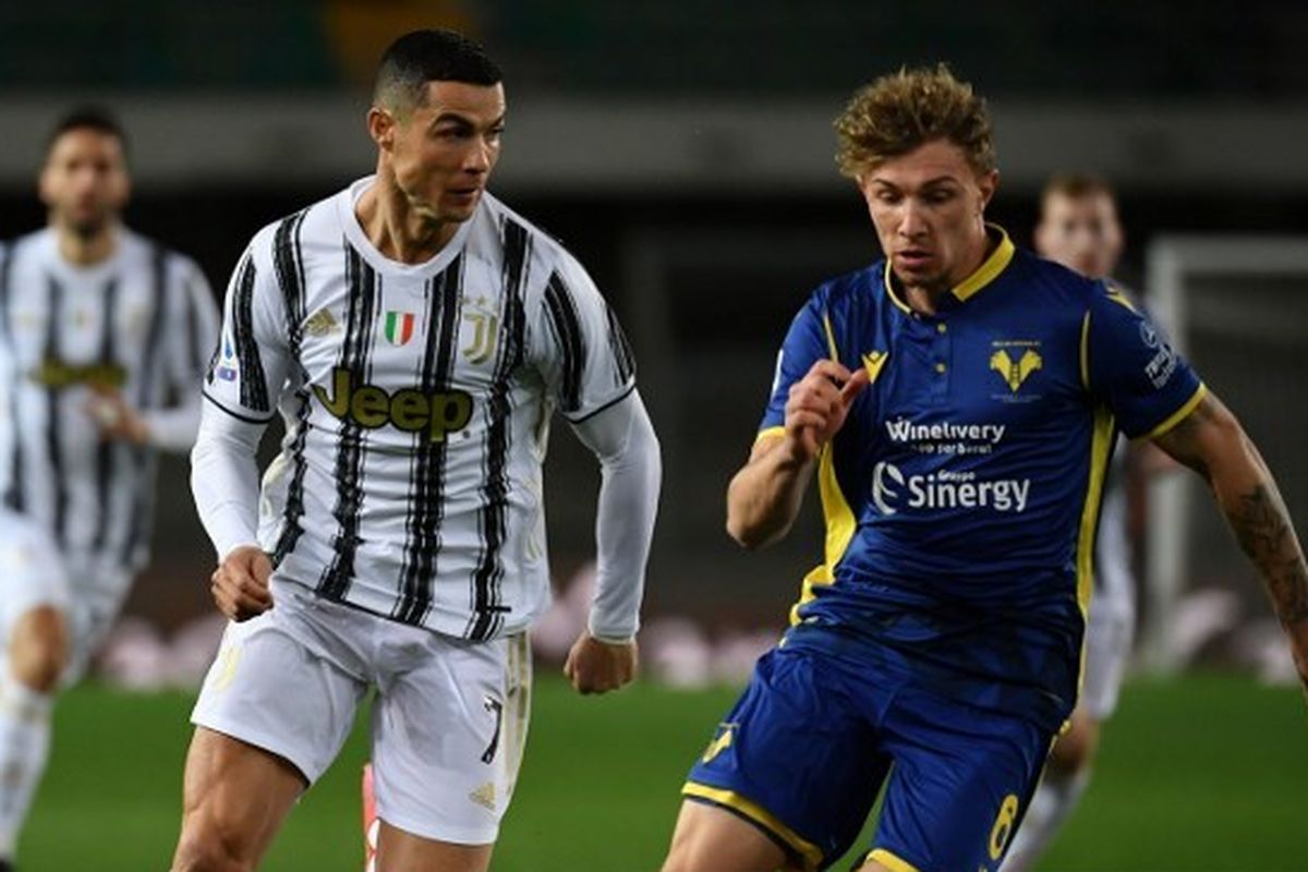 Cristiano Ronaldo menggiring bola dibayangi oleh Matteo Lovato dalam pertandingan Hellas Verona vs Juventus pada pekan ke-24 Liga Italia Serie A 2020-2021 yang digelar di Stadion Stadion Marc'Antonio Bentegodi, Sabtu (27/2/2021) malam waktu setempat. Foto: ISABELLA BONOTTO/AFP