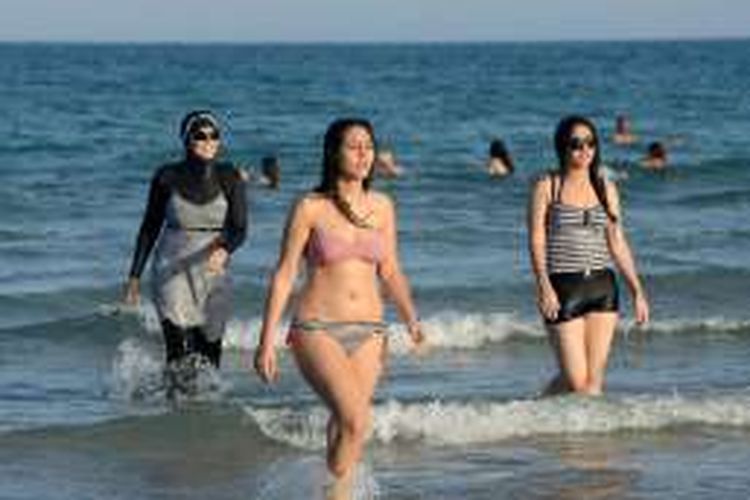 Wisatawan menggunakan burkini dan bikini di pantai Ghar el Melh, dekat Bizerte, Tusisia, 16 agustus 2016. Tiga hari sebelumnya, terjadi tawuran massal setelah wisatawan memotret orang yang sedang renang pakai burkini di Pulau Sisco, Perancis.