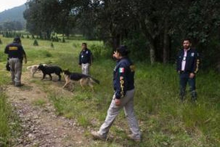 Dalam foto yang diambil pada 22 Agustus lalu ini, terlihat sekelompok polisi dibantu anjing pelacak mencoba mencari barang bukti kejahatan di daerah Tlalmanalco, tak jauh dari ibu kota, Mexico City.