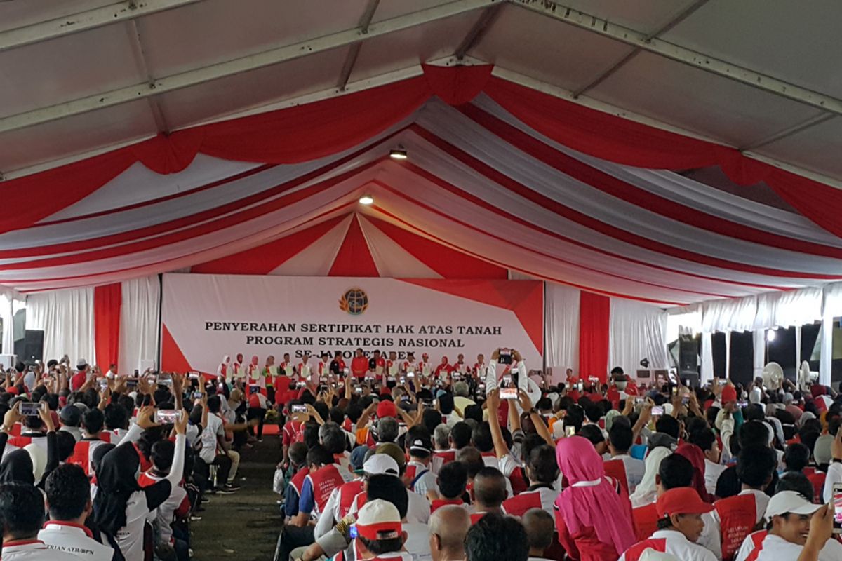 Presiden Joko Widodo menyerahkan sertifikat hak atas tanah kepada Gubernur DKI Jakarta Djarot Saiful Hidayat dan 13 perwakilan warga dalam acara penyerahan sertifikat hak atas tanah di Lapangan Park & Ride Jalan MH Thamrin, Jakarta Pusat, Minggu (20/8/2017).