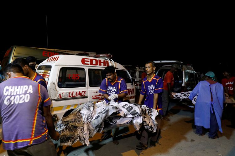 Petugas penyelamat membawa jenazah di luar kamar mayat rumah sakit, setelah pesawat Pakistan International Airlines jatuh di Karachi, pada 22 Mei 2020.
