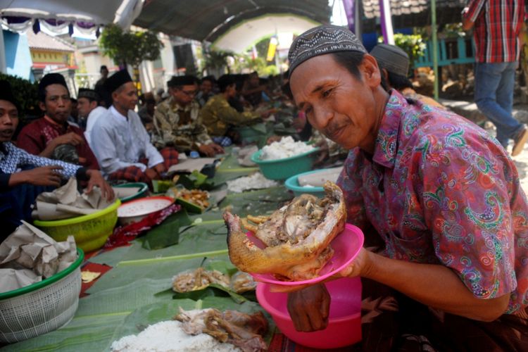 Warga Desa Guci, Kecamatan Godong, Kabupaten Grobogan, Jawa Tengah menggelar tradisi sedekah bumi atau apitan, di jalan kampung setempat, Senin (06/08/2018). Dalam tradisi budaya yang berusia ratusan tahun itu, ratusan warga bersama-sama menyantap 500 ekor ayam kampung yang dimasak utuh dengan bumbu (ingkung). Ingkung disajikan dengan nasi, oseng tempe, mie goreng, tempe dan tahu dengan dibungkus daun pisang. Tradisi apitan merupakan bentuk rasa syukur warga atas hasil pertanian yang melimpah.