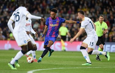 Penyerang Barcelona Pierre-Emerick Aubameyang mencoba melalui hadangan bek Napoli Amir Rrahmani (kanan) dalam laga play-off fase gugur Liga Europa musim 2021-2022 di Stadion Camp Nou, Jumat (18/2/2022) dini hari WIB.