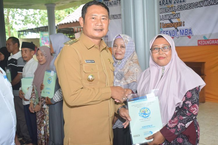 Bupati Lamongan Yuhronur Efendi, saat menyerahkan sertifikat secara simbolis kepada warga di Balai Desa Kedungwangi, Kecamatan Sambeng, Lamongan, Jawa Timur, Selasa (31/1/2023).