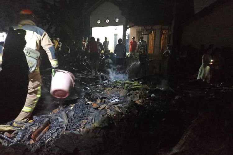 Petugas kepolisian tengah mengevakuasi jasad Isah (74) pemilik rumah panggung di Cileunyi, Kabupaten Bandung, Jawa Barat, yang meninggal dunia akibat kebakaran yang melanda rumahnya, Minggu (29/7/2024)