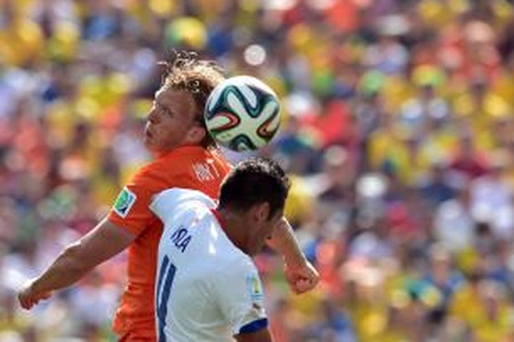 Striker Belanda, Dirk Kuyt (kiri), berebut bola dengan bek Cile, Mauricio Isla, dalam laga penyisihan Grup B Piala Dunia 2014 di Corinthians Arena di Sao Paulo, Senin (23/6/2014).