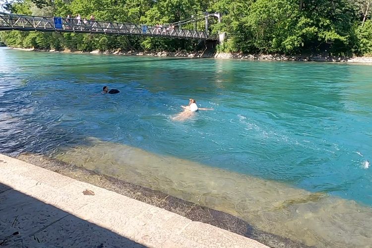 Dua orang Swiss berenang di Schoenausteg, lokasi yang menurut polisi Bern, Swiss menjadi tempat anak Ridwan Kamil, Emmeril Kahn Mumtadz atau Erill (23) mulai berenang di Sungai Aare, Selasa (31/5/2022) siang waktu setempat. Mereka berenang menggunakan dengan pelampung yang sekaligus menjadi tempat baju ganti.