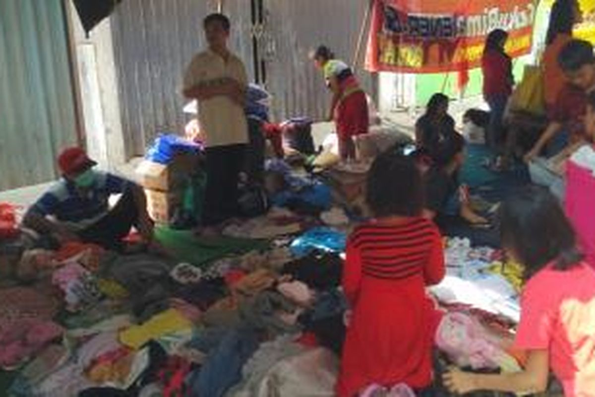 Warga dan anak-anak korban kebakaran di Kebon Sayur, Kelurahan Jembatan Besi, Tambora, Jakarta Barat, tampak memilih-milih pakaian bekas yang masih layak digunakan, Selasa (29/9/2015).