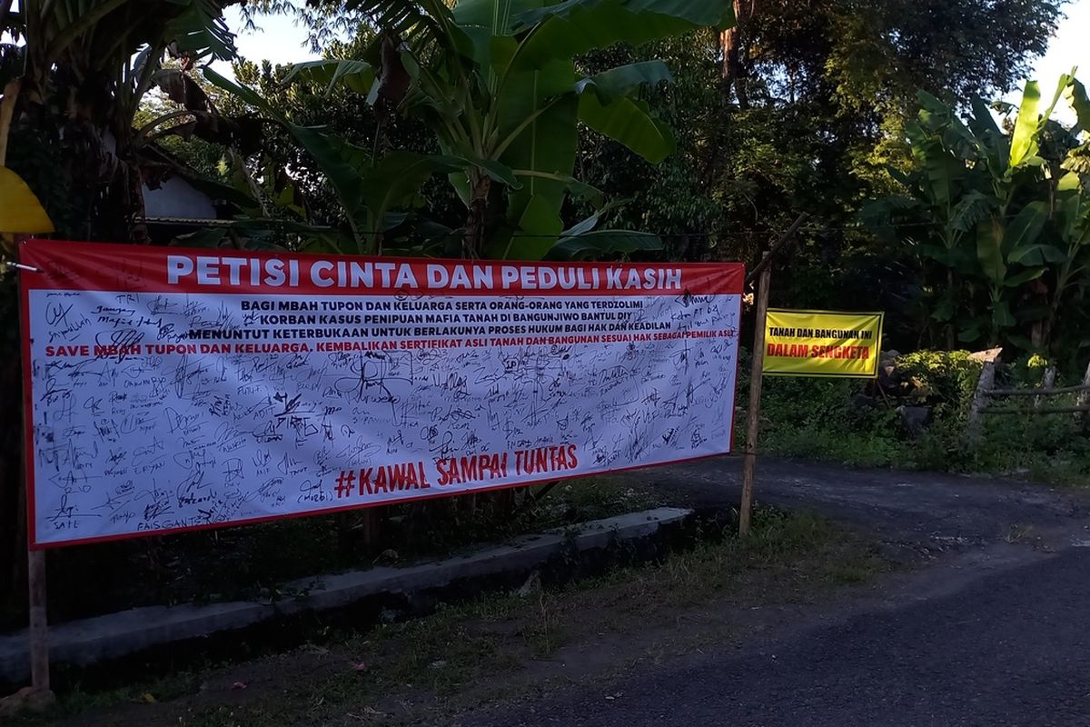 baner tanda tangan warga dan pengumuman tanah dalam sengeketa di halaman rumah Mbah Tupon, Sabtu (26/4/2025)