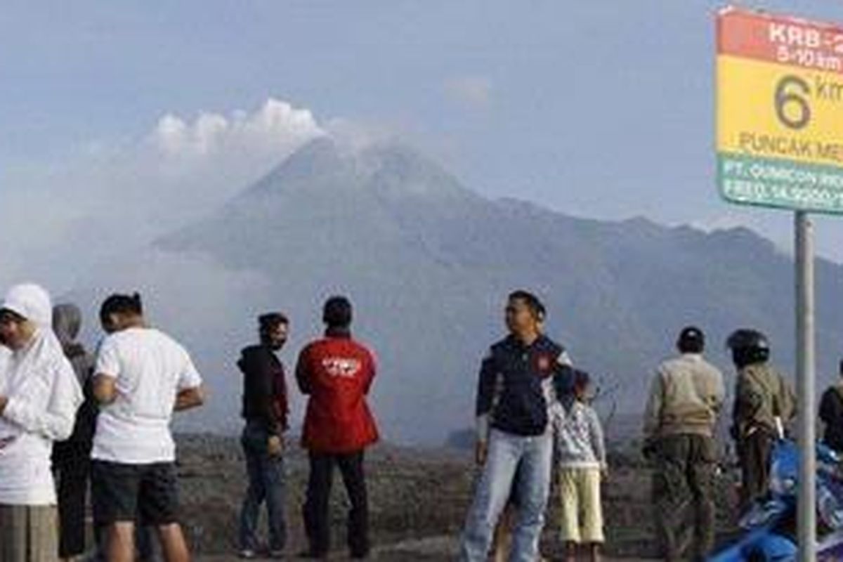 Sejumlah warga melihat Gunung Merapi dari Kopeng, Desa Kepuharjo, Kecamatan Cangkringan, Kabupaten Sleman, DI Yogyakarta, Minggu (5/11/2010). Pascapenurunan status dari awas menjadi siaga, banyak warga yang datang dari sejumlah kota untuk melihat kerusakan akibat erupsi Merapi di wilayah rawan bencana. 