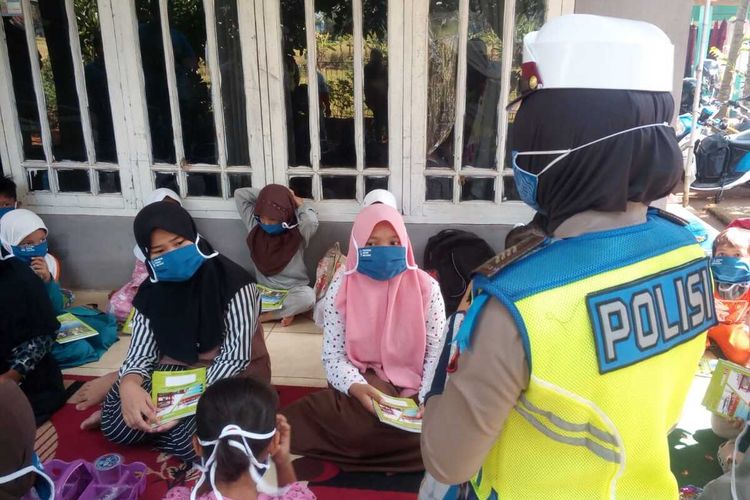 Seorang anggota polwan di Cianjur, Jawa Barat, membantu kegiatan belajar jarak jauh secara daring sekelompok siswa SD dengan meminjamkan ponsel miliknya, Selasa (28/7/2020).