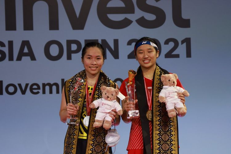 Tunggal putri Thailand, Ratchanok Intanon (kiri),  bersama tunggal putri Korea Selatan An Se Young pada panggung Indonesia Open 2021 dengan balutan selendang Bali.

