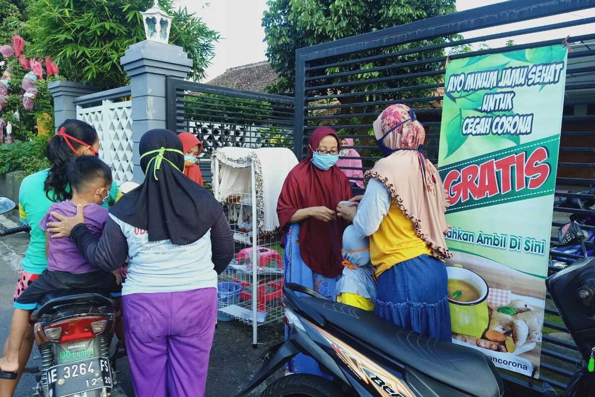 Nampak warga sementara mengambil jamu gratis yang dipercaya berkhasiat mencegah corona di Jalan Sentul, Kelurahan Banjarejo, Kecamatan Taman, Kota Madiun, Jawa Timur, Rabu (15/4/2020).