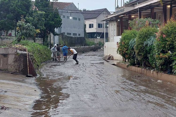 Warga di Kompleks Graha Indah membersihkan sisa material lumpur usai diterjang banjir, Senin (20/6/2022).
