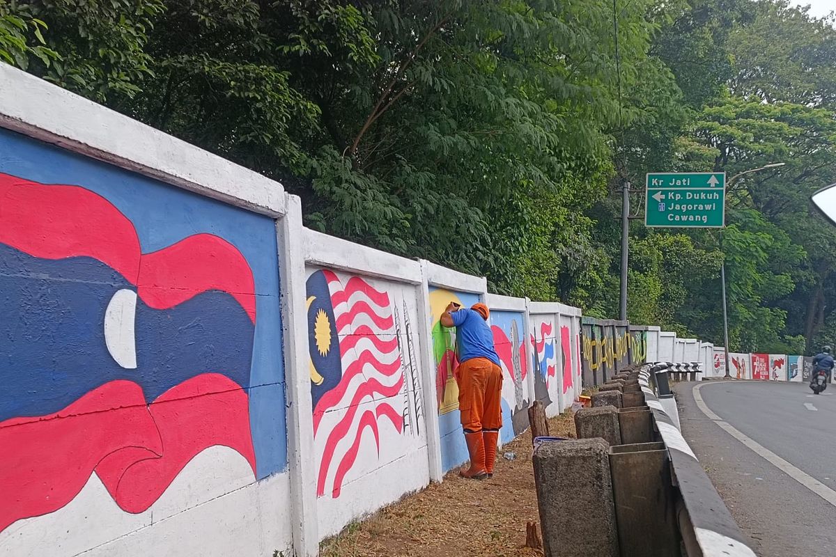 Gambar bendera negara peserta KTT ASEAN di tembok Jalan Raya Haji Bokir bin Djiun di Dukuh, Kramatjati, Jakarta Timur, Selasa (22/8/2023).