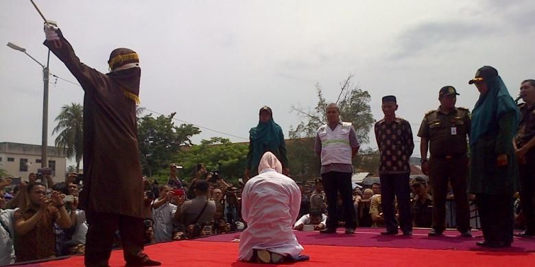Seorang terpidana cambuk melanggar qanun nomor 14/2003 menjalani hukuman cambuk sebanyak 5 kali cambuk di hadapan khalayak umum di Depan Mesjid Baitusshalihin Ulee Kareng, Banda Aceh, Jumat (18/9/2015). Sebanyak 18 terpidana cambuk menjalankan eksekusi dihari yang sama di Banda Aceh.