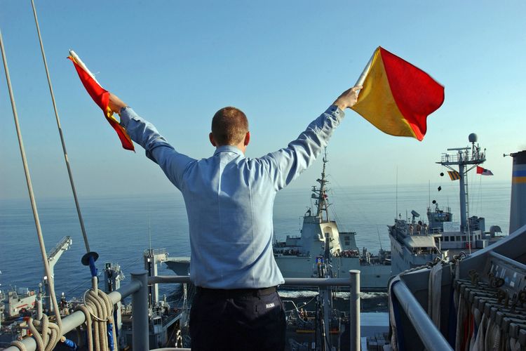 Pelaut sedang mengirimkan pesan menggunakan bendera semaphore
