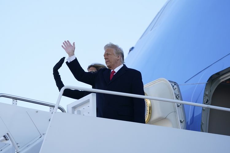 Presiden Amerika Serikat (AS) Donald Trump dan Ibu Negara Melania melambaikan tangan sebelum mereka masuk ke Air Force One di Pangkalan Gabungan Andrews, Maryland, pada 20 Januari 2020. Trump dan istrinya akan berangkat ke Mar-a-Lago di Florida, dan takkan menghadiri pelantikan Joe Biden.