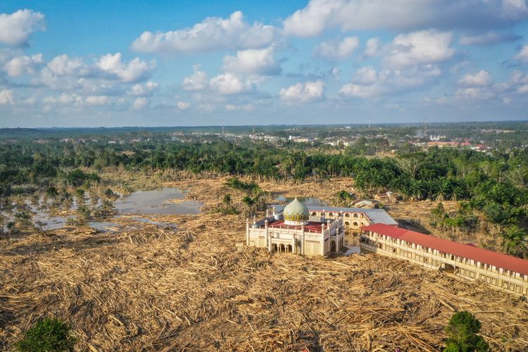 Foto udara menampilkan tumpukan kayu-kayu memenuhi area Pondok Pesantren Darul Mukhlishin pascabanjir bandang di  Desa Tanjung Karang, Karang Baru, Kabupaten Aceh Tamiang, Aceh, Jumat (5/12/2025). Aceh Tamiang Disebut Kota Zombie usai Banjir, Ini 5 Fakta Kondisinya