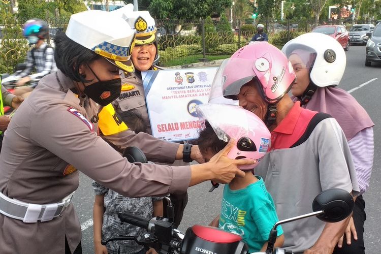 Petugas Ditlantas Polda Riau memberikan helm gratis kepada anak-anak pada Operasi Zebra di Jalan Jenderal Sudirman, Kota Pekanbaru, Riau, Senin (3/10/2022) petang.