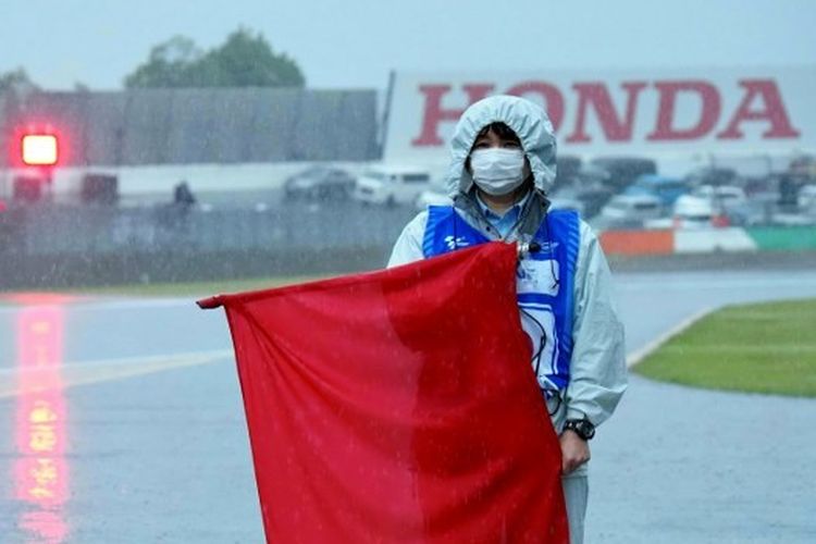 Marshal mengibarkan bendera merah atau red flag di tengah berlangsungnya kualifikasi Moto2 Jepang 2022 di Sirkuit Motegi, Prefektur Tochigi, Sabtu (24/9/2022). Red flag dikibarkan menyusul hujan deras yang mengguyur Sirkuit Motegi.