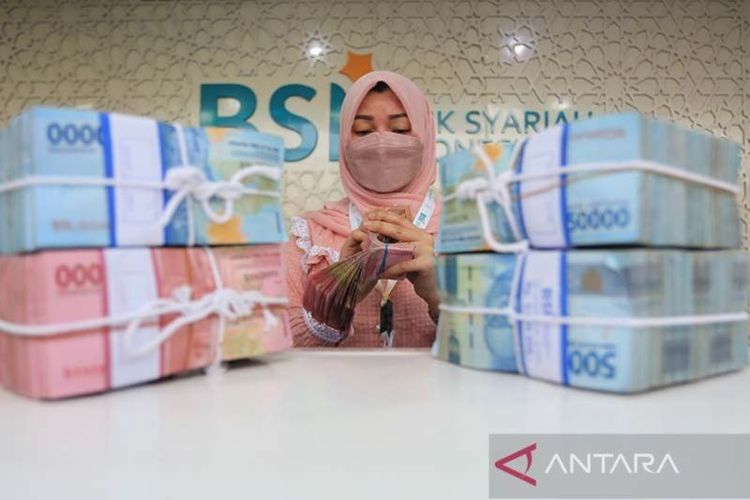 Karyawan Bank Syariah Indonesia sedang menghitung uang.