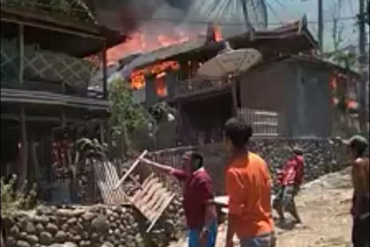 Warga Kabupaten Gowa, Sulawesi Selatan, berusaha memadamkan api yang membakar 12 unit rumah, Jumat (28/9/2018).