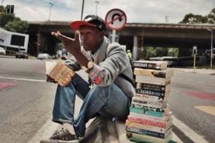 Philani Dhadla (24) dan tumpukan buku dagangannya di salah satu sudut jalan kota Johannesburg, Afrika Selatan.