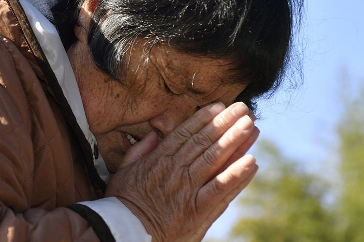 Seorang wanita yang kehilangan suami dan cucunya akibat gempa Jepang dan tsunami 2011, berdoa di depan makam di Miyako, prefektur Iwate, Jepang, pada Kamis (11/3/2021). Jepang menggelar peringatan 10 tahun bencana yang melanda wilayah Fukushima tersebut.