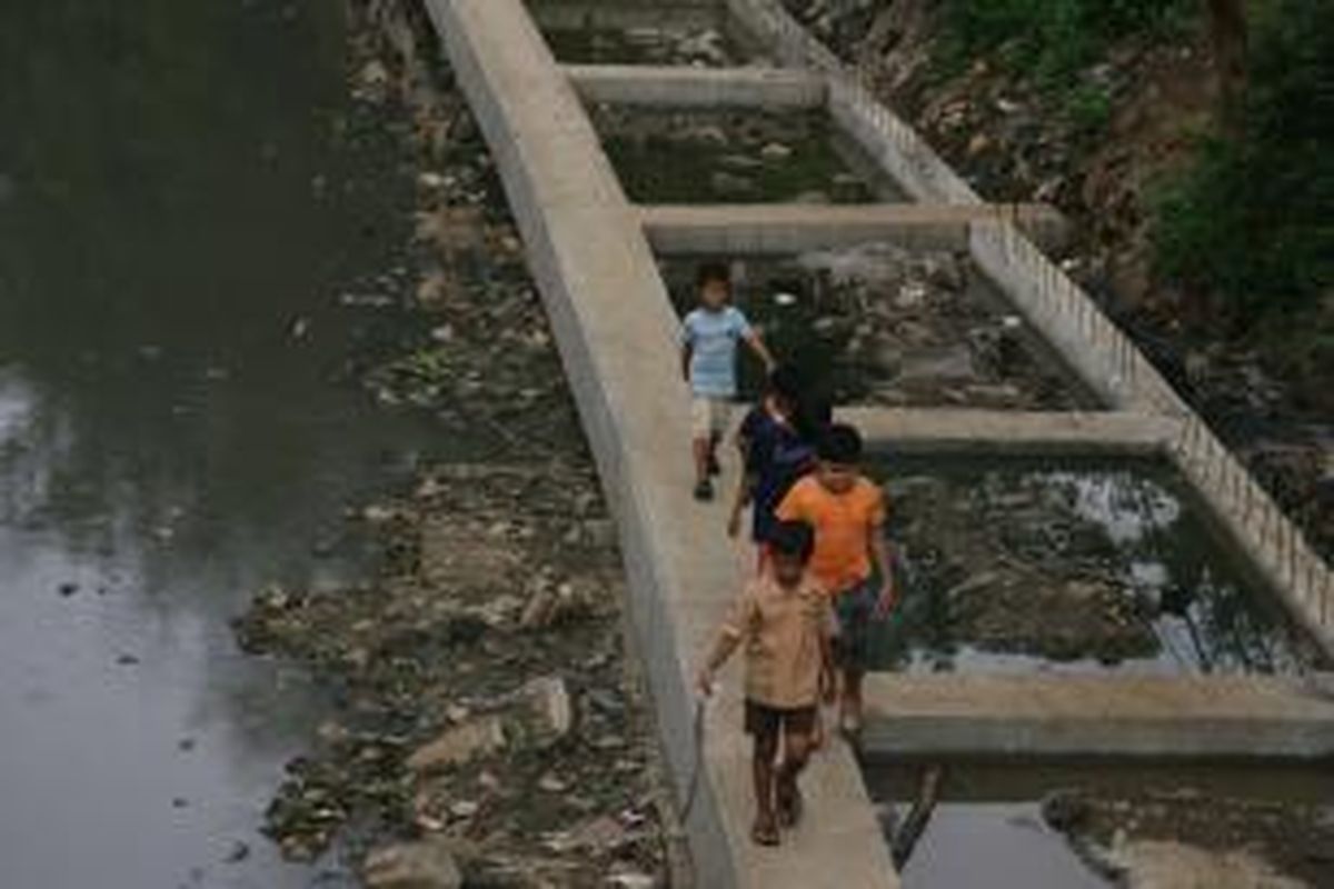 Tanggul Beton Ciliwung - Anak-anak bermain di tanggul beton yang baru dibangun pada proyek revitalisasi sungai Ciliwung di kawasan Proklamasi, Jakarta, Kamis (18/7). Pembangunan tanggul beton untuk menahan erosi akibat luapan sungai yang bisa mengakibatkan banjir. Pembangunan normalisasi Sungai Ciwilung dan pekerjaan infrastruktu lain, meningkatkan kebutuhan akan beton pracetak.