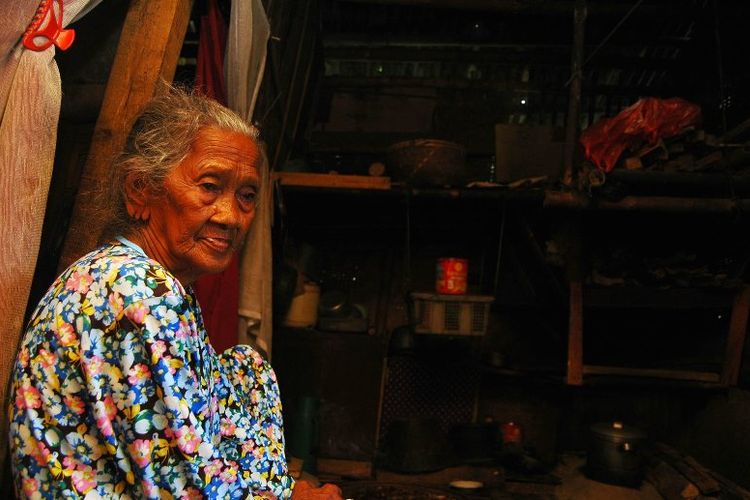 Nenek Roni (97), sedang duduk di dalam rumahnya yang terbuat dari
bilik bambu, Minggu (16/4/2017). Lebih dari 20 tahun nenek Roni hidup
satu atap bersama makam almarhum suaminya, di Kampung Kubang, Desa
Banjarwaru, Ciawi, Bogor, Jawa Barat.