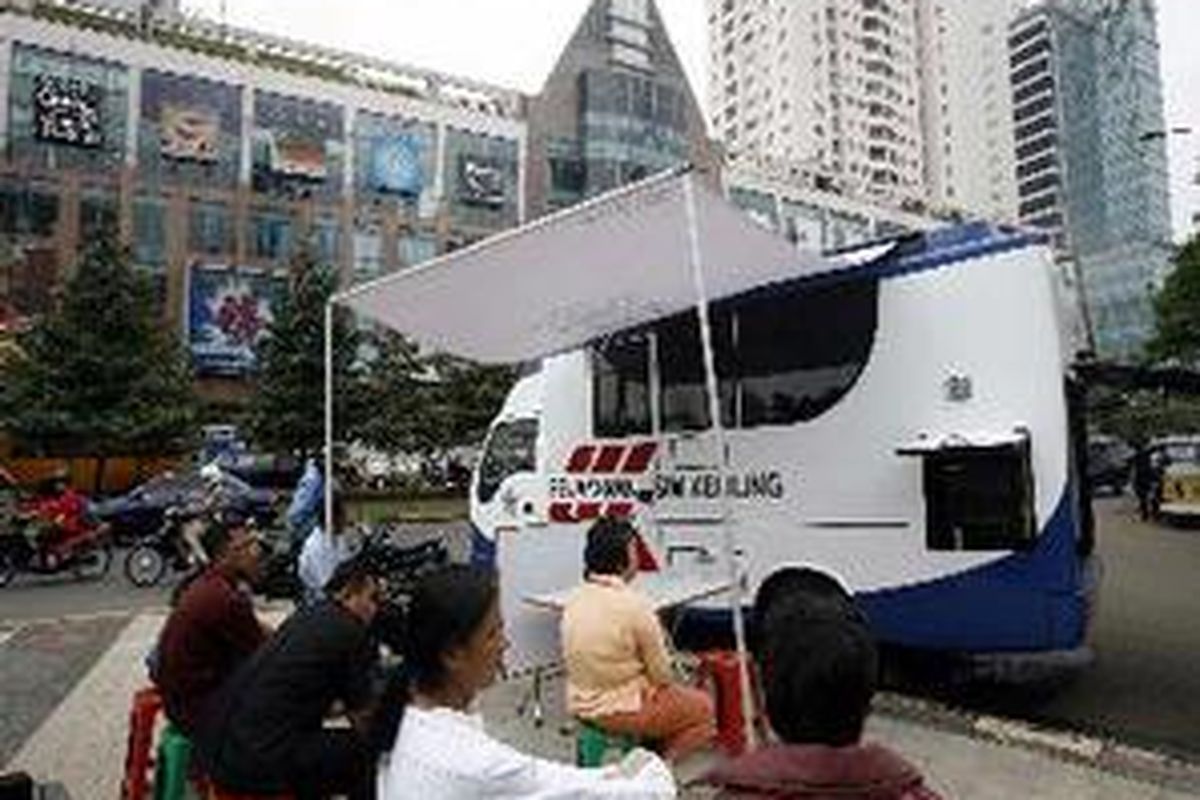 Sejumlah warga antre untuk perpanjangan surat izin mengemudi (SIM) yang dilayani mobil keliling dari Kepolisian Daerah (Polda) Metro Jaya di kawasan Karet Kuningan, Jakarta Selatan, Rabu (31/1). Adanya mobil itu membantu warga Ibu Kota yang senantiasa diburu waktu. Saat ini Polda Metro Jaya telah memiliki tujuh mobil keliling untuk melayani perpanjangan SIM.