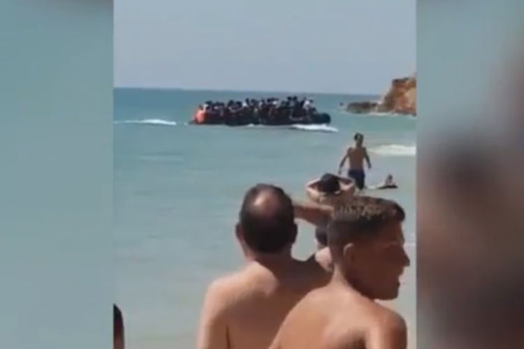 Pengunjung Pantai Barrosa di Spanyol terkejut dengan kedatangan perahu yang membawa puluhan migran pada Minggu (26/8/2018). (Twitter/Daniel Caballero via Express)