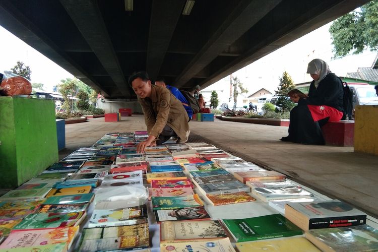 Warga tengah memilih buku pada lapak baca Perpustakaan Jalanan Karawang di Taman Milenial Karawang, Rabu (22/1/2020).