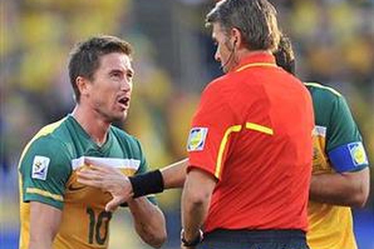 Pemain Australia Harry Kewell (kiri) memprotes wasit Roberto Rosetti (tengah) yang mengganjarnya dengan kartu merah pada pertandingan Australia versus Ghana di penyisihan grup Piala Dunia 2010 di Stadion Royal Bafokeng, Sabtu (19/6/2010).