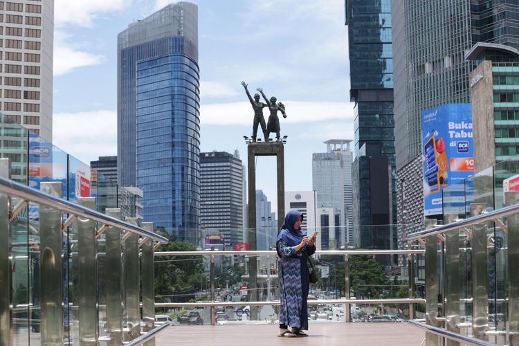 Pengunjung berfoto di anjungan Halte Transjakarta Bundaran Hotel Indonesia, Jakarta, Jumat (28/10/2022). Warga Ibu Kota datang ke halte yang belum sepenuhnya rampung itu untuk antre berfoto demi dapat latar belakang Patung Selamat Datang.