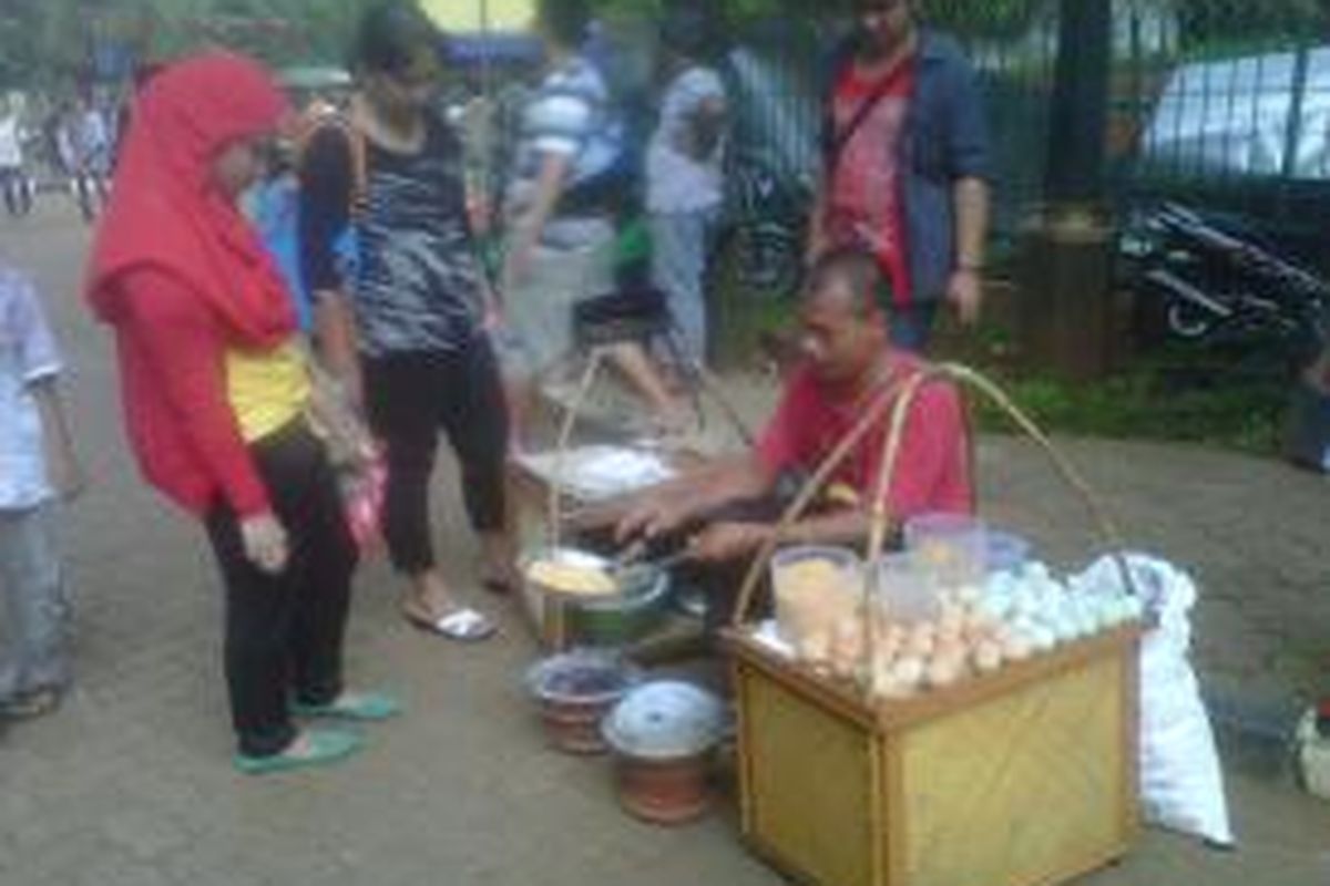 Pedagang kerak telor sedang melayani. membludaknya pengunjung di Taman Margasatwa Ragunan memberikan keuntungan sendiri baginya.