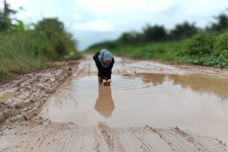 Kondisi jalan rusak yang dijadikan tempat obyek foto model di Kecamatan Pulau Rimau,Kabupaten Banyuasin, Sumatera Selatan.