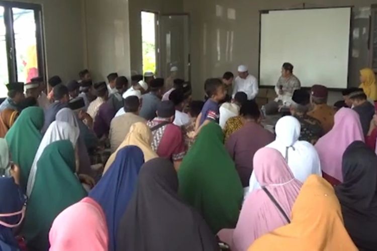 Kemenag Pasangkayu kumpulkan warga dan tokoh masyarakat untuk sosialisasi soal shalat berjamaah di rumah untuk hindari penyebaran Covid-19, Sabtu (11/4/2020). Ironisnya, para warga duduk berdekatan dan tidak mengenakan masker. Tampak Kepala Kemenang Pasangkayu Mustafa memberikan arahan ke warga,