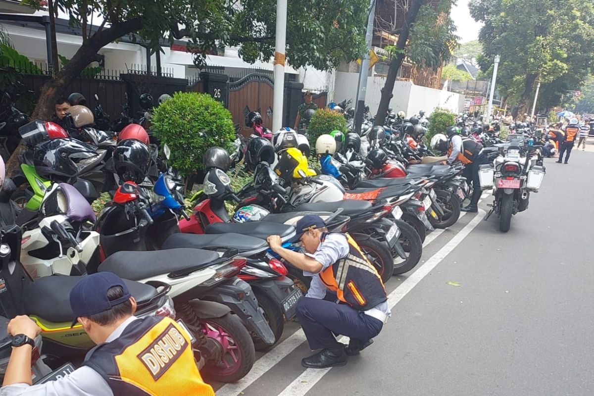 Penampakan petugas Suku Dinas Perhubungan Jakarta Selatan saat melakukan penertiban terhadap kendaraan yang parkir liar di Jalan Senopati, Kebayoran Baru, Jakarta Selatan 