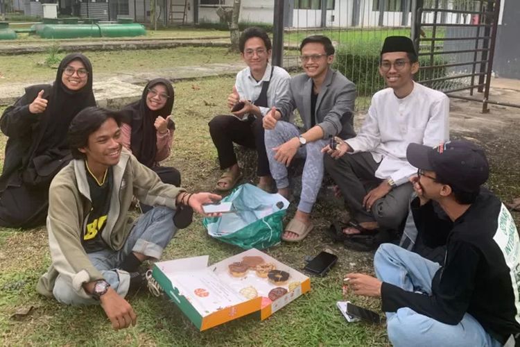 Muhammad Mufid memakan kue donat bersama dengan mahasiswa-mahasiswa WNI lainnya yang berhasil dievakuasi dari Khartoum, Sudan pada Jumat (28/4/2023).