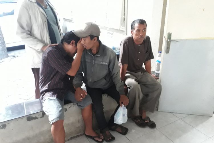 Dedit Prasetyo (kiri) menangis di pundak kerabatnya di kamar jenazah RSU dr Soetomo Surabaya